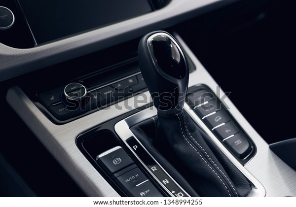 Selector\
automatic transmission with perforated leather in the interior of a\
modern expensive car. The background is\
blurred