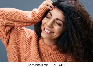 SELF CARE CONCEPT. Cheerful tanned curly Latin female in warm sweater enjoy holiday time hold hand on head posing isolated over gray blue background close eyes. Copy space Mockup Banner Fashion offer - Shutterstock ID 2178106181