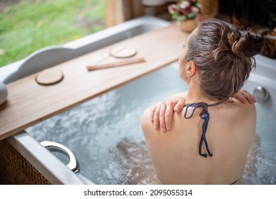 Self care concept. Woman embracing herself in a hot tub. - Powered by Shutterstock