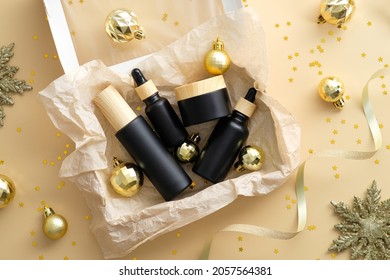 Self Care Package, Seasonal Gift Box With Black And Wooden Bottles And Christmas Golden Balls, Decorations On Pastel Begie Background.