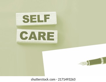 SELF CARE - text on wooden cubes on a red gradient background.