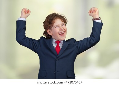 Self Confident Boy With Raised Fists Celebrating A Recent Success