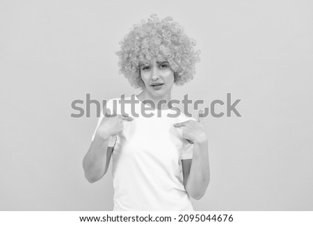 self confident freaky woman in curly clown wig poonting finger on herlesf, smug