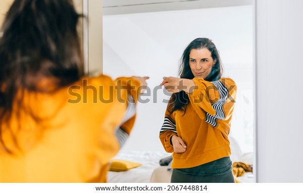 \
Self\
confident single woman pointing finger at her reflection in mirror,\
dancing and felling good. Independent person with high self esteem\
talks positive and I can do it motivation.\
