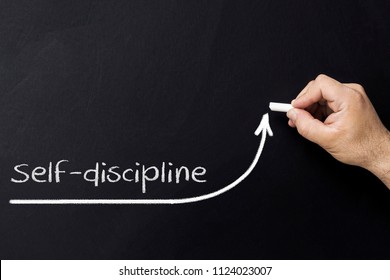 Self discipline concept. Hand with chalk drawing rising arrow. Discipline and self motivation - Shutterstock ID 1124023007
