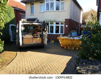 Self Employed Builder Van With Building Tools & Yellow Skip Full Of Rubbish Situated Near The House. Photo For Background Use As Home Renovation, Investment Project. Space To Add Text On Driveway.