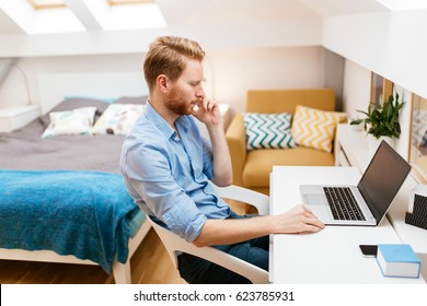 Self Employed Businessman Working From Home On Laptop