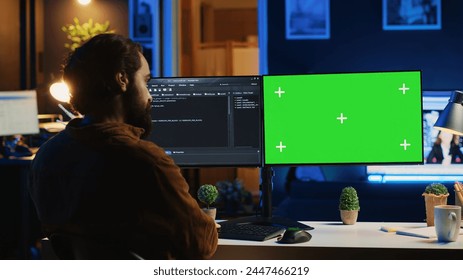 Self employed man doing IT support job from apartment personal office, coding on green screen PC. Software developer writing lines of code on mockup computer at home, camera A - Powered by Shutterstock - Get 15% off with code: PIKWIZARD15