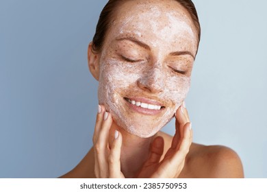 Self love. Skin care beauty portrait. Facial scrub, young happy woman with a freckles is applying white peeling cosmetic product to whole her face. Daily skincare routine. Dermatology. Exfoliating - Powered by Shutterstock