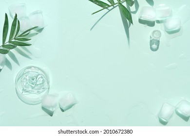 Self made moisturizer with ice cubes and exotic palm leaves on mint green background. Minimal flat lay, top view with copy-space, place for text or product. Facial massage concept, handmade cosmetics. - Shutterstock ID 2010672380