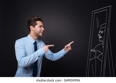 Self motivation  Cheerful handsome young man smiling   pointing at himself in mirror while standing against isolated black background 
