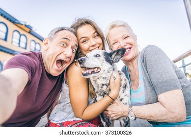 Self portrait of happy family with dog having fun outdoors - Grandparents and nephew taking a selfie - Powered by Shutterstock