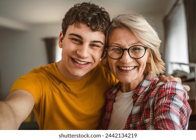 self portrait selfie of mother and son mature woman and young man at home happy - Powered by Shutterstock