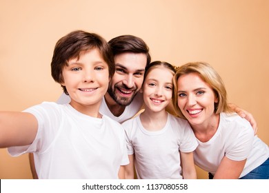 Self portrait of young adorable beautiful smiling family, bearded father, blonde mother and their little children, boy and girl, wearing white T-shirts on beige background