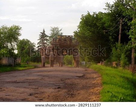 Self propelled crop sprayers driving along a rural road toward agricultural fields
