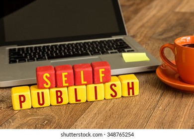 Self Publish written on a wooden cube in a office desk