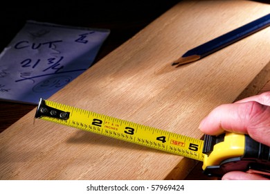 Self Retracting Construction Tape Measure And Carpenter Pencil On Wood Plank For A Custom Cabinetry Woodworking Project In A Carpentry Workshop