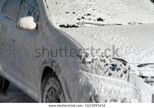 Self service high pressure car wash. Vehicle covered\
with foam