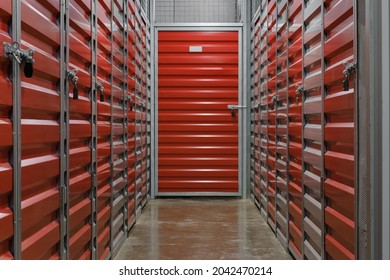 Self Storage Facility, Red And Gray Metal Doors With Locks. Storage Corridor Warehouse. Moving, Organizing, Storage Concept.