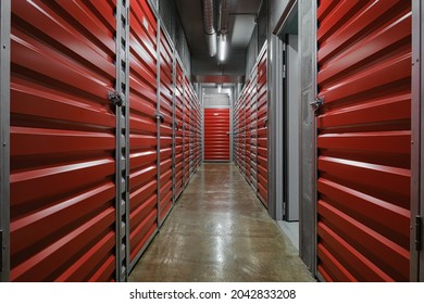 Self Storage Facility, Red And Gray Metal Doors With Locks. Storage Corridor Warehouse. Moving, Organizing, Storage Concept.