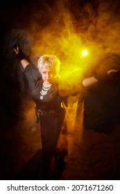 Self-assured Adult Blonde Middle Age Woman With Black Angel Wings. Model Posing In Studio On Black Background. Dangerous Cupid On Valentine's Day