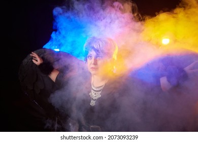 Self-assured Adult Blonde Middle Age Woman With Black Angel Wings. Model Posing In Studio On Black Background. Dangerous Cupid On Valentine's Day