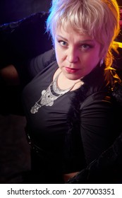 Self-assured Adult Blonde Middle Age Woman With Black Angel Wings. Model Posing In Studio On Black Background. Dangerous Cupid On Valentine's Day In Studio