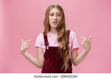 Self-assured arrogant young female student with high ego standing cocky and brag about herself pointing at her with cool snobbish look looking away to right with contempt posing over pink wall - Shutterstock ID 2089202269