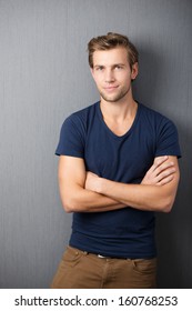 Self-assured Handsome Man Standing With His Arms Crossed In Smart Casual Clothing Against A Dark Studio Background