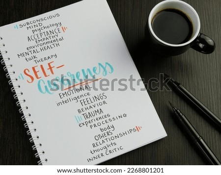 SELF-AWARENESS word cloud in notebook with cup of espresso and pens on black wooden desk