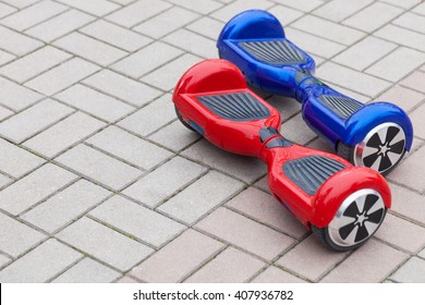 Self-balancing Scooter.Modern Transportation Technology.Electric Mini Segway.Fun Way To Ride City Streets On Electric Power.Red And Blue Gyroscooters In Park