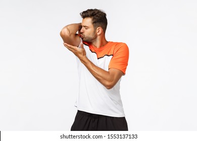 Self-centered Handsome Macho Man, Sportsman In Activewear, Bragging Own Body Shape, Raise Arm And Kiss Muscle Or Biceps With Satisfaction, Lost Weight, Become Strong After Productive Workout