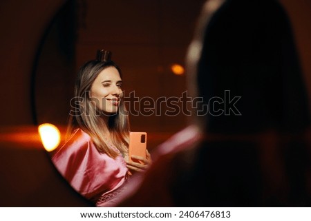 
Self-Confident Girl Checking herself in the Mirror Taking Selfies. Pretty princess admiring herself feeling strong and self-confident
