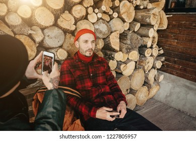 Self-confident Photographer Does Portrait Of Man By The Phone On Background Of Sawmill And Warehouse Of Trees