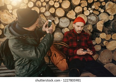 Self-confident Photographer Does Portrait Of Man By The Phone On Background Of Sawmill And Warehouse Of Trees