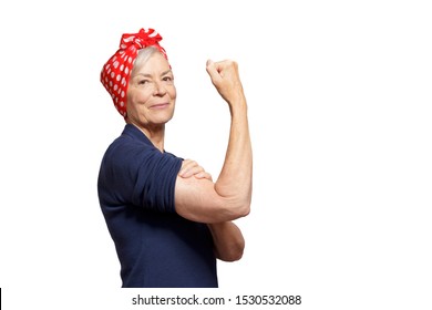 Self-confident senior woman with a clenched fist rolling up her sleeve, isolated on white, copyspace