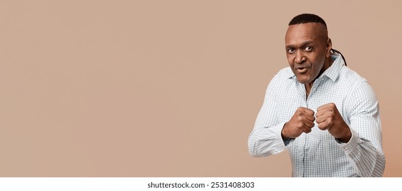 Self-defence concept. Mature african american man with fight gesture, punching fists ready to hit, orange background. - Powered by Shutterstock