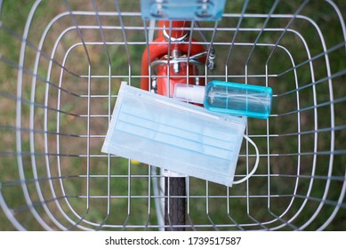 Self-defense Before Leaving The House, Mask And Alcohol Spray In  Bicycle Basket, Top View.