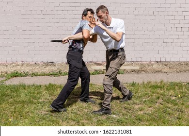 Self-defense of a Krav Maga against a knife attack. Martial arts instructors demonstrate self-defense techniques of Krav Maga - Powered by Shutterstock