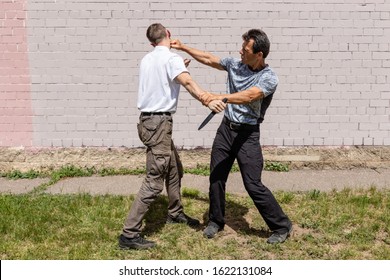 Self-defense of a Krav Maga against a knife attack. Martial arts instructors demonstrate self-defense techniques of Krav Maga - Powered by Shutterstock