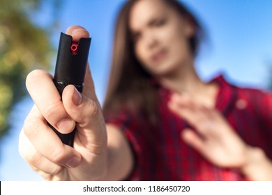 Self-defense. A young woman protects herself in the park from criminals, thieves and hooligans with the help of pepper spray. Self defense woman