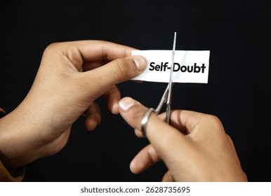 Self-Doubt concept background with hand cutting the text paper. Confidence, no self doubt