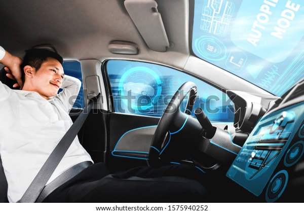 Self-driving autonomous car with relaxed young\
man sitting at driver seat is driving on busy highway road in the\
city. Concept of machine learning, artificial intelligence and\
augmented reality.