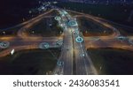 Self-driving autonomous cars move along a suburban traffic intersection in the evening. Neon HUD elements visualize the interaction of driverless cars connected to a common network	

