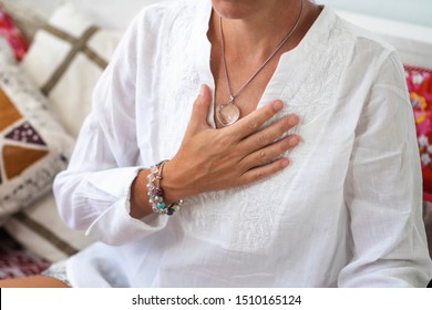 Self-Healing Heart Chakra Meditation. Woman Sitting In A Lotus Position With Right Hand On Heart Chakra. Spiritual Awakening.