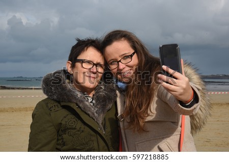 Similar – Image, Stock Photo funny twin sisters make a selfie with the smartphone