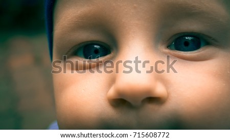 Selfie Baby face close up.Seven-month-old white child with blue eyes in blue hat outdoor.