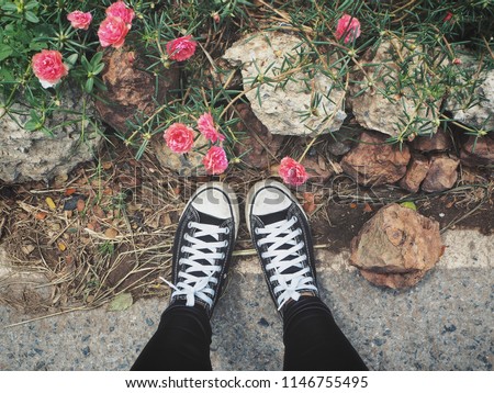 Selfie of black sneakers with flowers