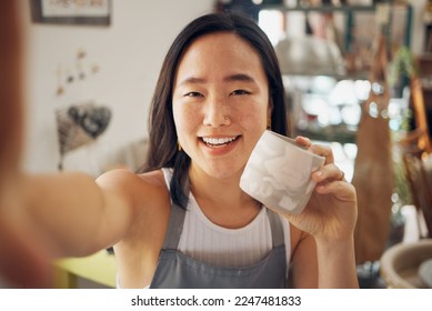 Selfie, ceramic art and creative asian woman smile in pottery studio or worship for mug product design, culture creativity and artistic development. Artist woman, happy portrait and mud sculpture - Powered by Shutterstock