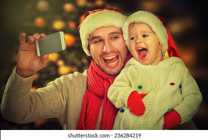 Selfie  In Christmas. Happy Family Father Dad Playing With Baby Daughter And Photographed On A Mobile Phone